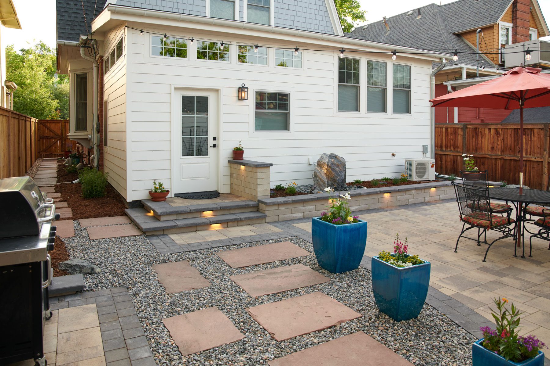 Landscape design with patio, outdoor lighting and outdoor kitchen in Cherry Creek, CO